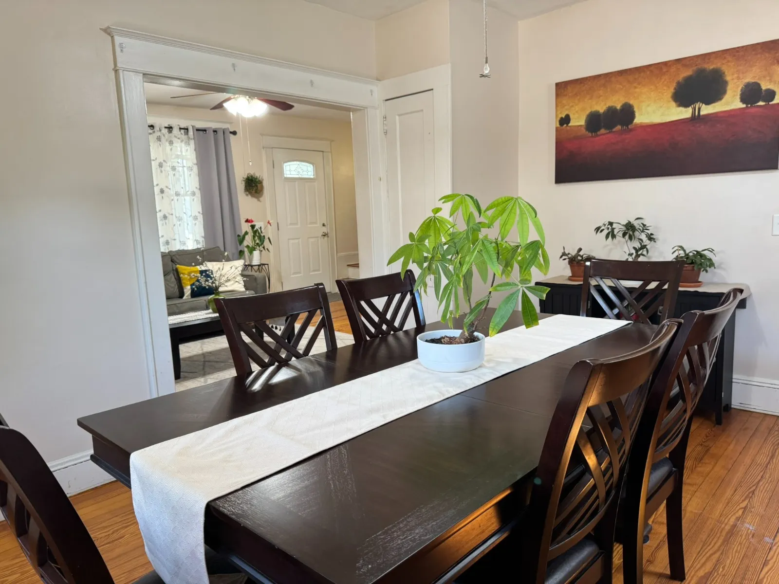Dining room after restyling by Kultur & Decor: dining looking through to foyer/living (front door + sofa visible); shows open flow.