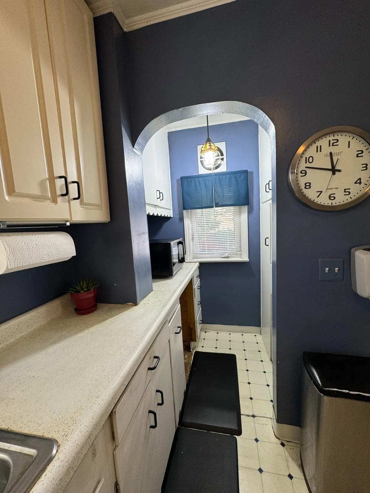 Kitchen after restyling by Kultur & Decor: kitchen archway to breakfast nook with Tiffany-style pendant (detail).
