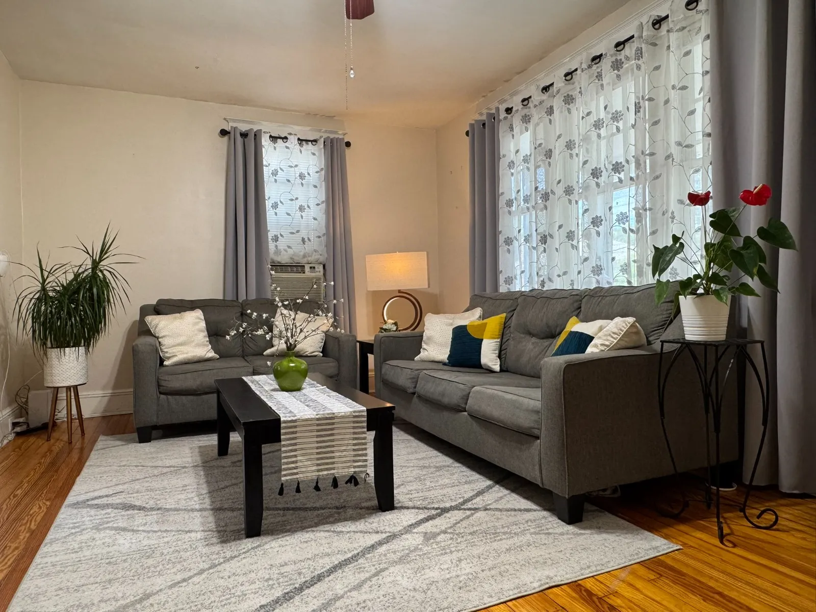 Living room after restyling by Kultur & Decor: living room, daytime: both sofas, lamp, anthurium.