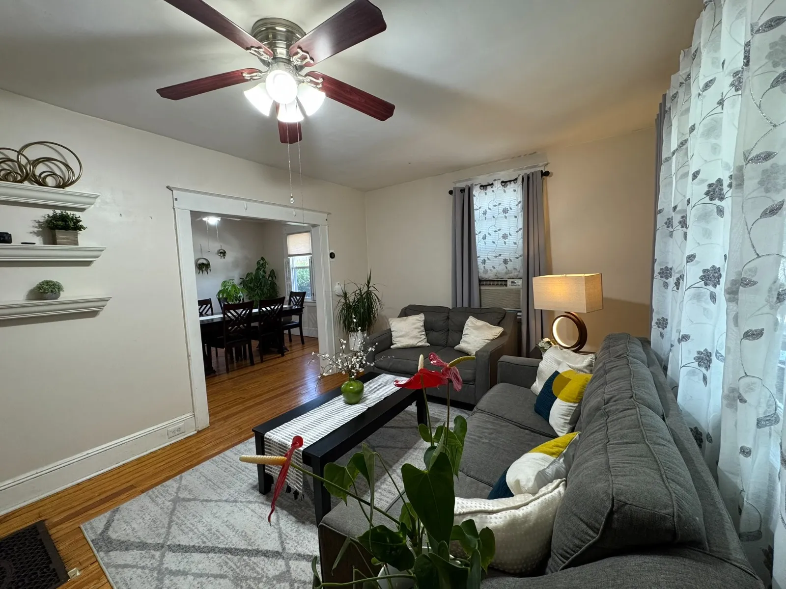 Living room after restyling by Kultur & Decor: living room toward mantel/floating shelves + dining doorway.