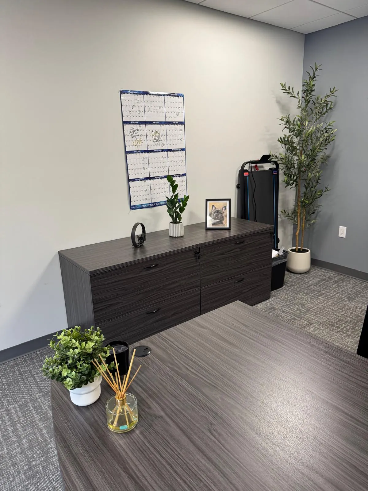 Office after restyling by Kultur & Decor: styled desk landscape: credenza, branded chair, printer.